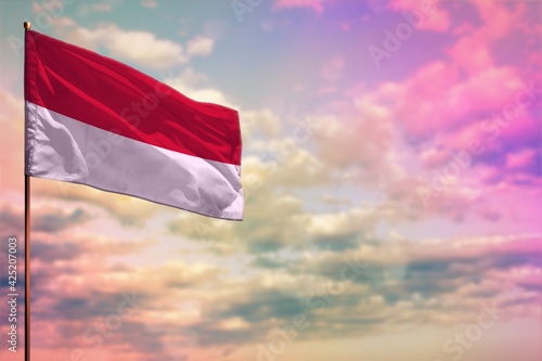 Fluttering Monaco flag mockup with the space for your content on colorful cloudy sky background. photo