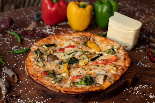  sliced Pizza on a wooden background with Mozzarella cheese, Tomatoes, pepper, Spices and Fresh Basil. Italian pizza. Pizza Margherita or Margarita