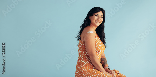 Photography Woman with band-aid on arm after getting vaccine