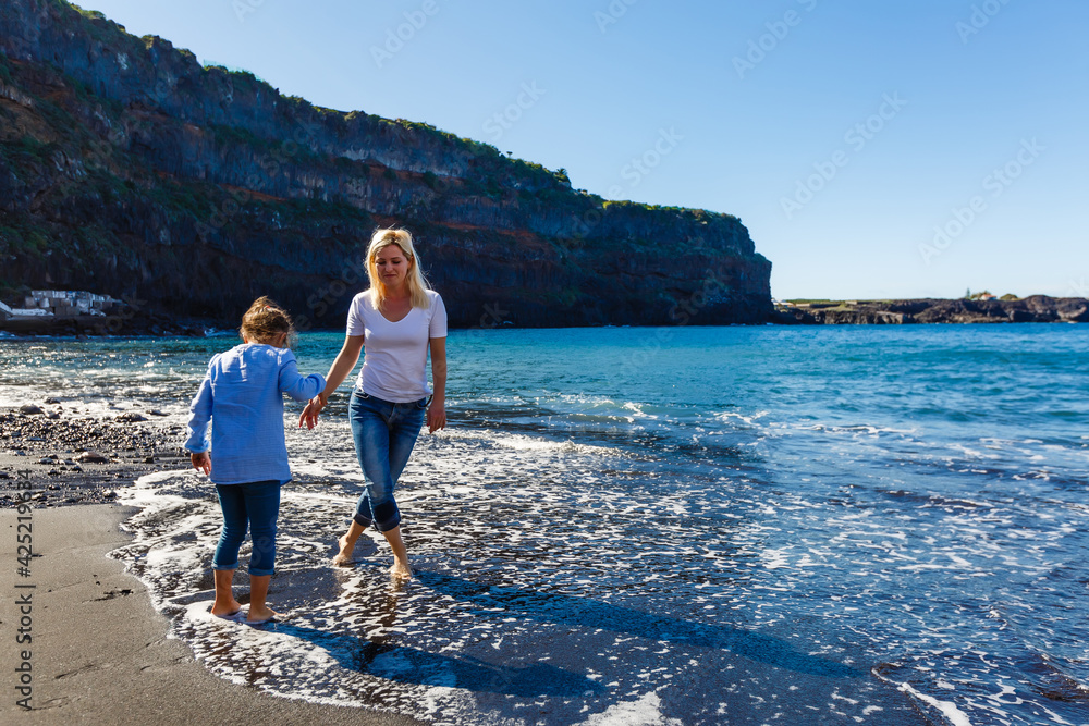 Family holiday on Tenerife, Spain. Mother with children outdoors on ocean. Portrait travel tourists - mom with kids. Positive human emotions, active lifestyles. Happy young family on sea beach