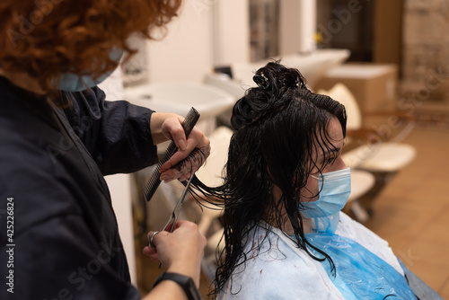 Hair cutting technique in young lady hair at salon