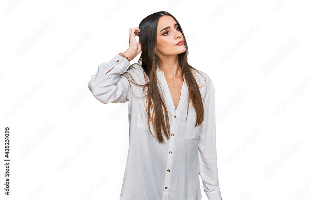 Young beautiful woman wearing casual white shirt confuse and wondering about question. uncertain with doubt, thinking with hand on head. pensive concept. Young beautiful woman wearing casual white shirt confuse and wondering about question. uncertain with doubt, thinking with hand on head. pensive concept.