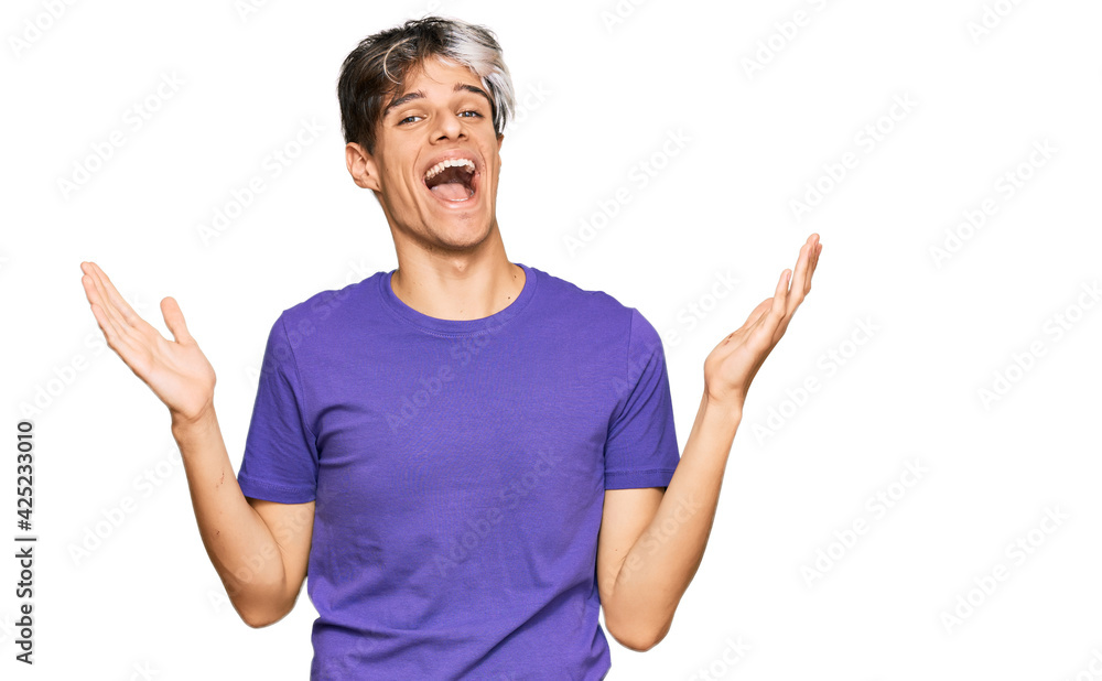 Young hispanic man wearing casual clothes celebrating victory with happy smile and winner expression with raised hands Young hispanic man wearing casual clothes celebrating victory with happy smile and winner expression with raised hands
