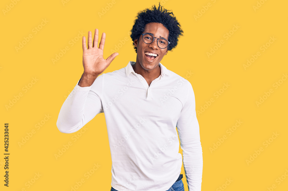 Handsome african american man with afro hair wearing casual clothes and glasses waiving saying hello happy and smiling, friendly welcome gesture Handsome african american man with afro hair wearing casual clothes and glasses waiving saying hello happy and smiling, friendly welcome gesture
