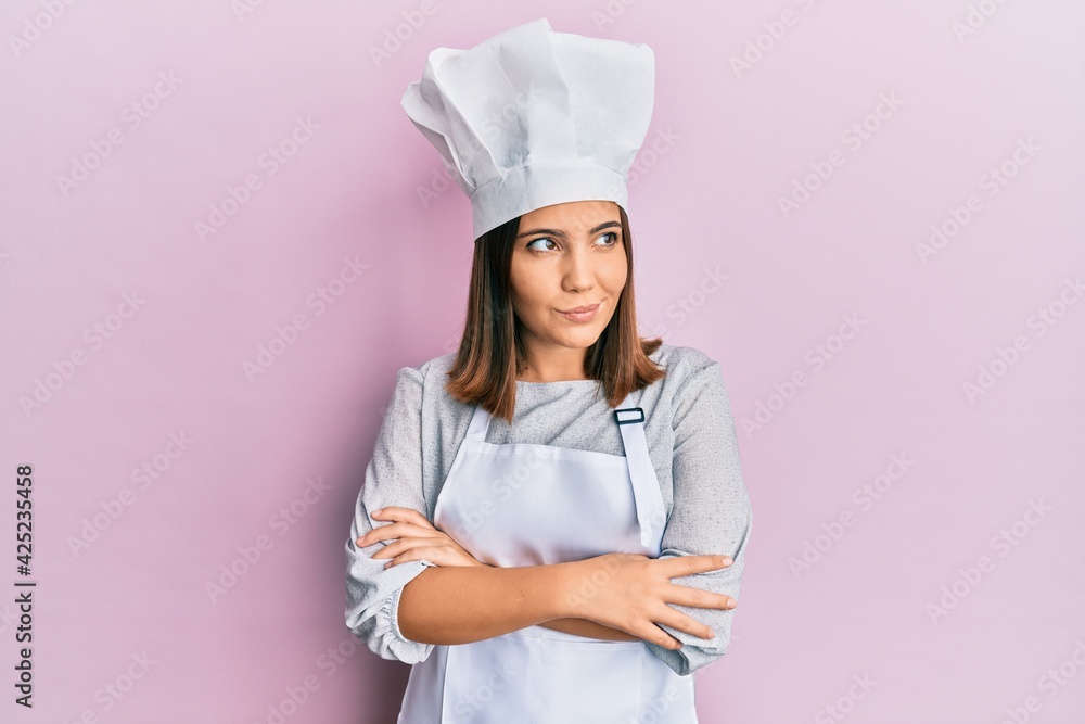 Young beautiful woman wearing professional cook uniform and hat smiling looking to the side and staring away thinking. Young beautiful woman wearing professional cook uniform and hat smiling looking to the side and staring away thinking.