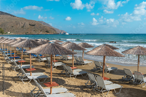 Beach with umbrellas on the Mediterranean coast. Crete. Greece.  © Zadvornov