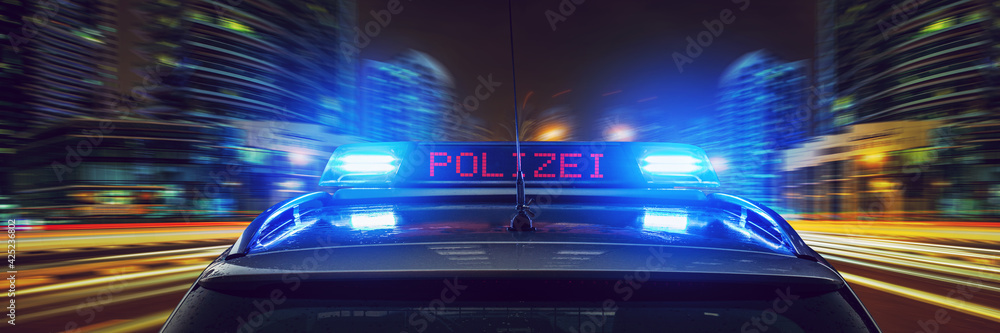 Polizei Auto mit Blaulicht bei Nacht in einer Stadt Stock Photo