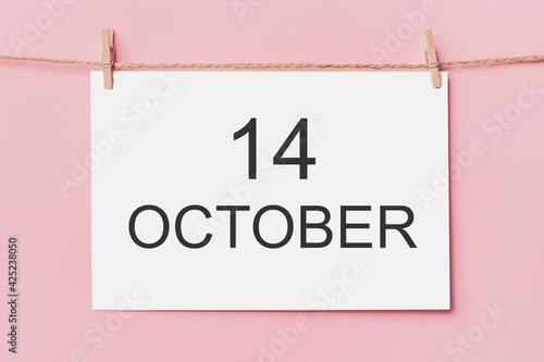 note letter pin on rope on pink background, love and valentine concept with text 14 October