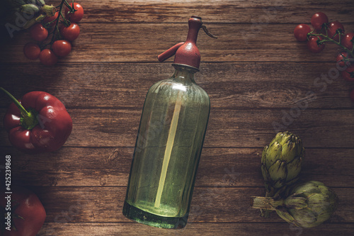 Tableau sur toile Flat lay retro food photography of an antique soda siphon, fresh cherry tomatoes, antique cutlery, artichokes and red pepper on a wood table