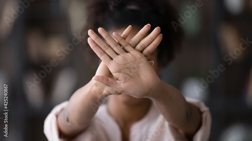 African American young woman show stop or no hand gesture or sign protest against racial or gender discrimination. Biracial female demonstrate object against domestic violence or abortion. photo