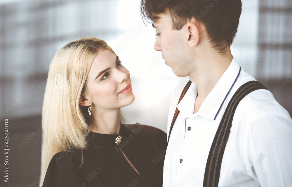 Young couple of businessman and woman are standing in a modern office. Portrait of successful business people Young couple of businessman and woman are standing in a modern office. Portrait of successful business people