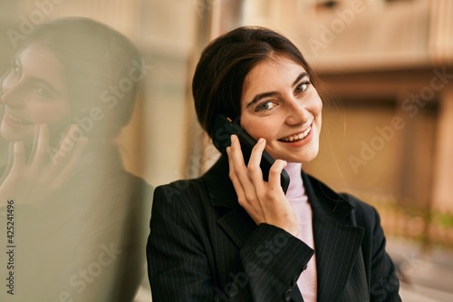 Young beautiful businesswoman smiling happy talking on the smartphone at the city.