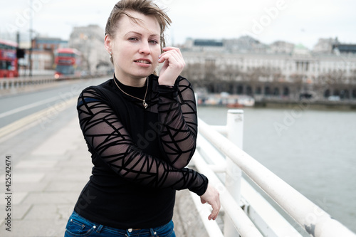 Atractive young woman posing in Waterloo bridge in London in a windy and cloudy day. photo