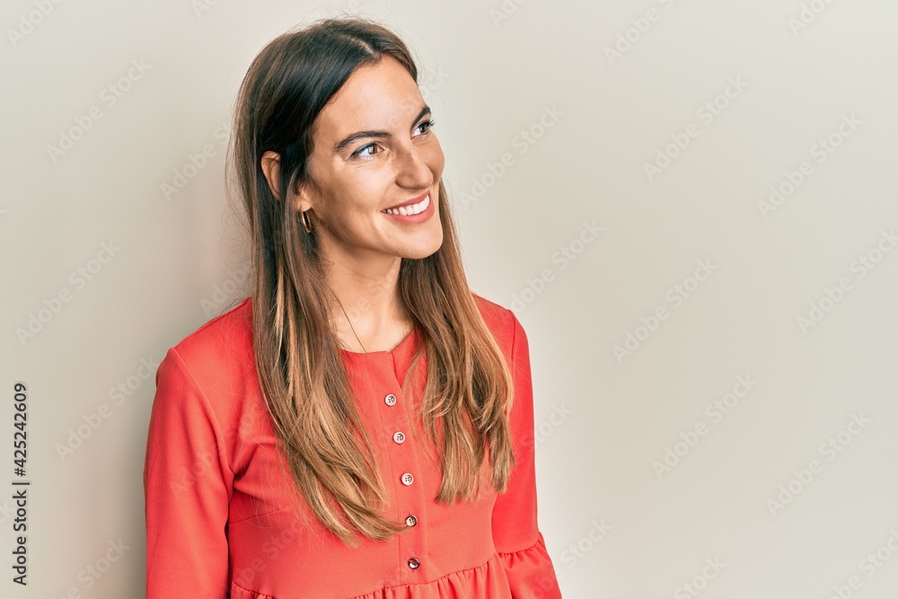 Young beautiful woman wearing casual clothes looking away to side with smile on face, natural expression. laughing confident. Young beautiful woman wearing casual clothes looking away to side with smile on face, natural expression. laughing confident.