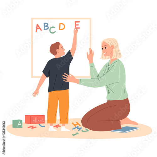 Child makes an English alphabet of letters on the board