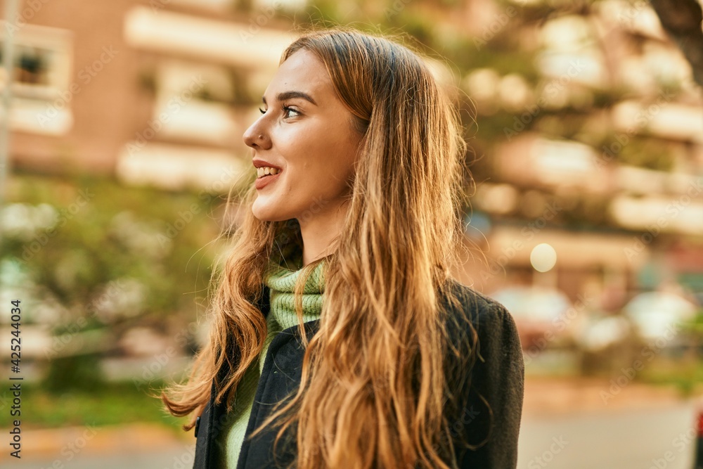 Fototapeta premium Young blonde girl smiling happy standing at the city.