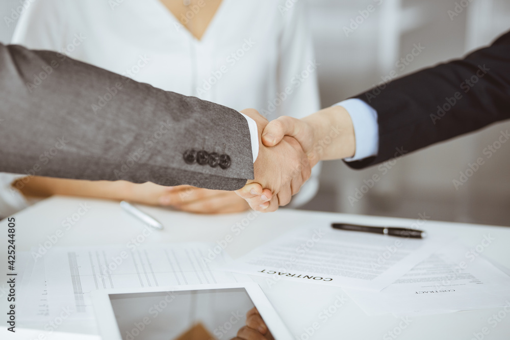 Business people shaking hands finishing contract signing, close-up. Business communication concept. Handshake and marketing Business people shaking hands finishing contract signing, close-up. Business communication concept. Handshake and marketing