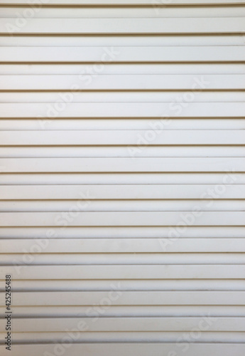 Closeup of the grille pattern on the white PVC door .