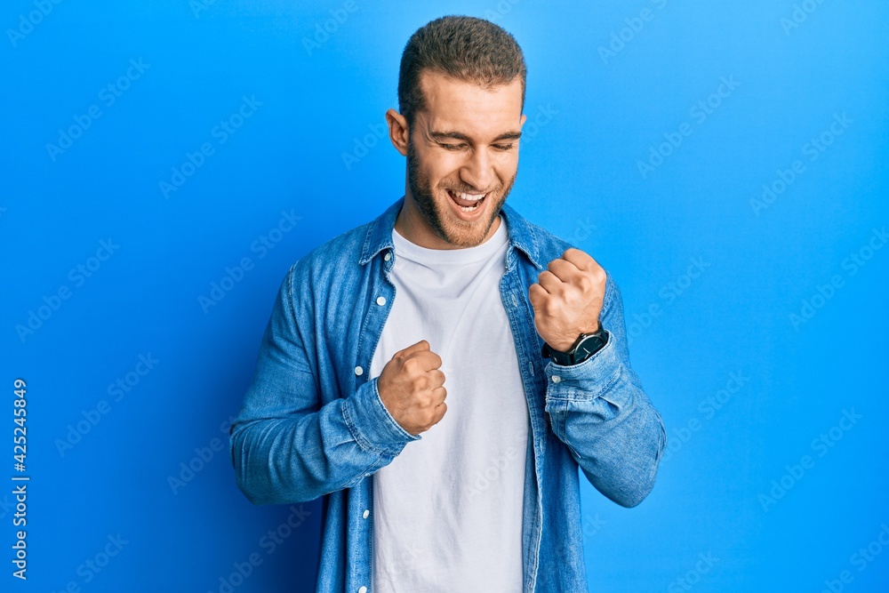 Young caucasian man wearing casual clothes celebrating surprised and amazed for success with arms raised and eyes closed Young caucasian man wearing casual clothes celebrating surprised and amazed for success with arms raised and eyes closed