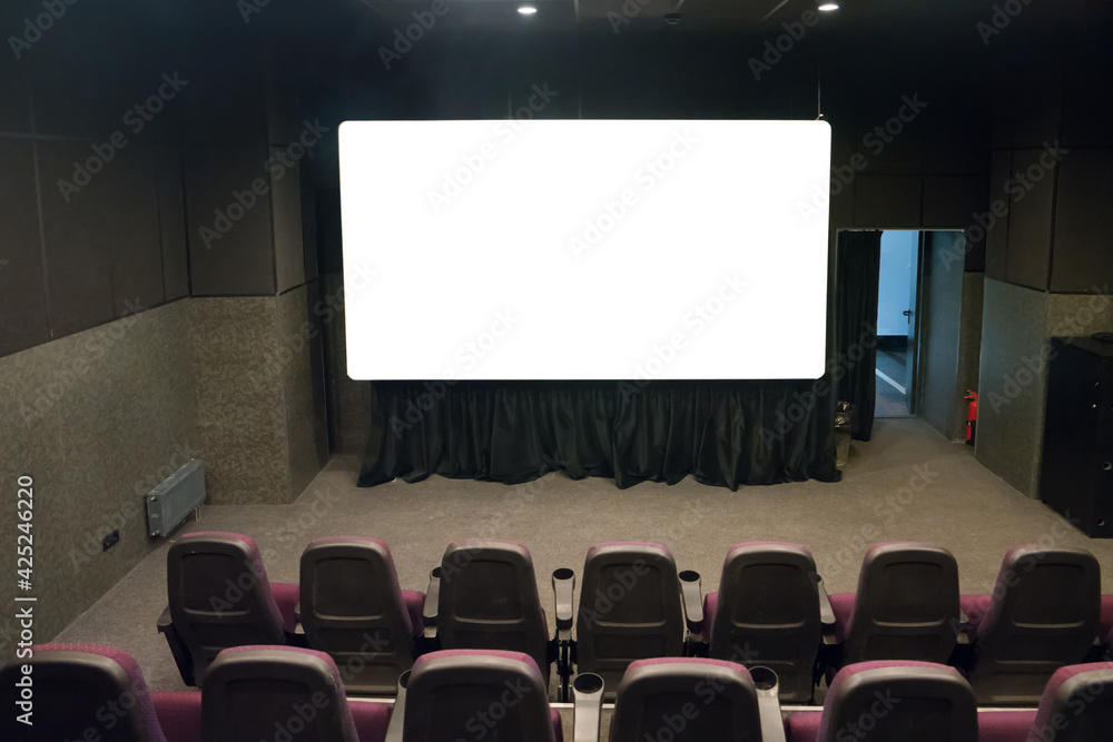 Empty stage in the small movie theater with white isolated screen
