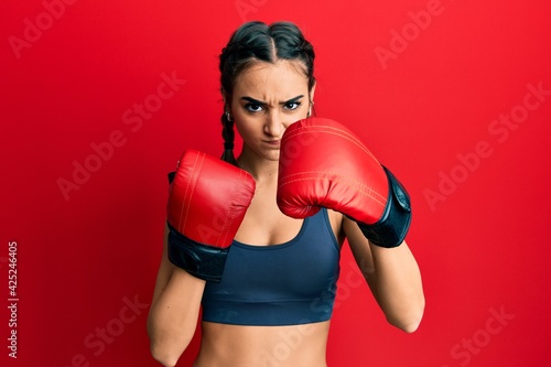 Young brunette girl using boxing gloves skeptic and nervous, frowning upset because of problem. negative person. © Krakenimages.com