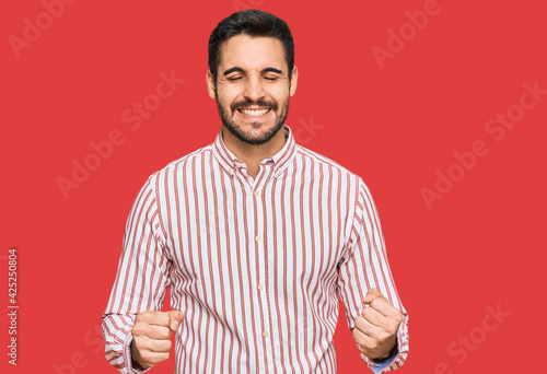 Young hispanic man wearing business shirt excited for success with arms raised and eyes closed celebrating victory smiling. winner concept.