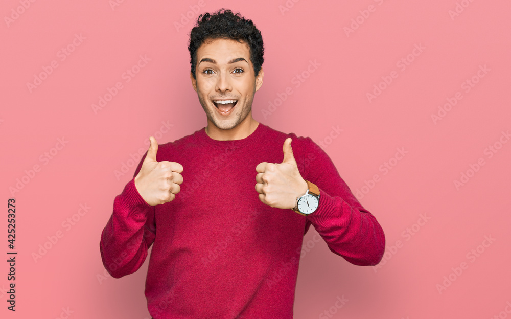 Young handsome man wearing casual clothes success sign doing positive gesture with hand, thumbs up smiling and happy. cheerful expression and winner gesture. Young handsome man wearing casual clothes success sign doing positive gesture with hand, thumbs up smiling and happy. cheerful expression and winner gesture.