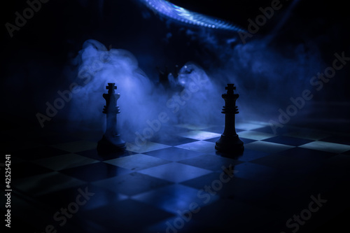 chess board game concept of business ideas and competition and strategy ideas concep. Chess figures on a dark background with smoke and fog and window with sunlight. Selective focus