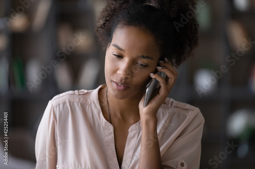 Young African American woman user have pleasant cellphone call with client or customer. Millennial biracial female talk speak on modern smartphone gadget, use good mobile provider connection.