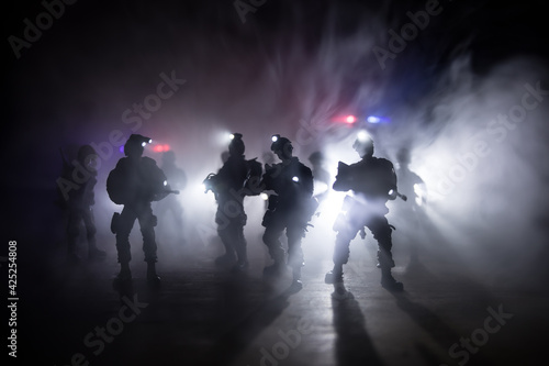 Anti-riot police give signal to be ready. Government power concept. Police in action. Smoke on a dark background with lights. Blue red flashing sirens. Dictatorship power