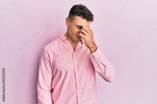 Hispanic young man wearing casual clothes tired rubbing nose and eyes feeling fatigue and headache. stress and frustration concept.