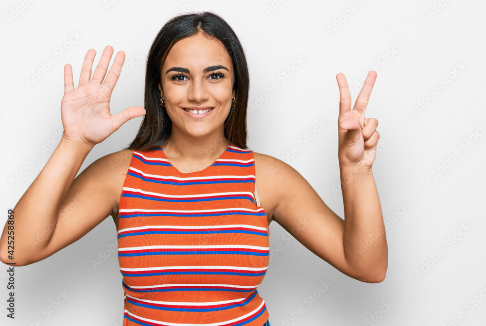 Young brunette woman wearing casual clothes showing and pointing up with fingers number eight while smiling confident and happy. Young brunette woman wearing casual clothes showing and pointing up with fingers number eight while smiling confident and happy.