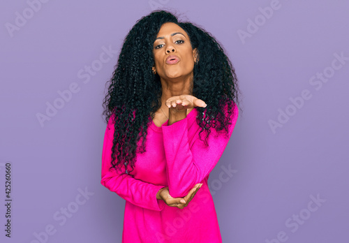 Middle age african american woman wearing casual clothes looking at the camera blowing a kiss with hand on air being lovely and sexy. love expression. © Krakenimages.com