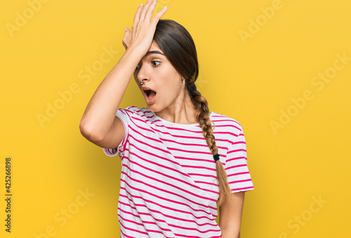 Young hispanic woman wearing casual clothes surprised with hand on head for mistake, remember error. forgot, bad memory concept.