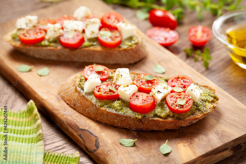 Bruschetta Appetizers with cherry tomatos pesto and mozzarella