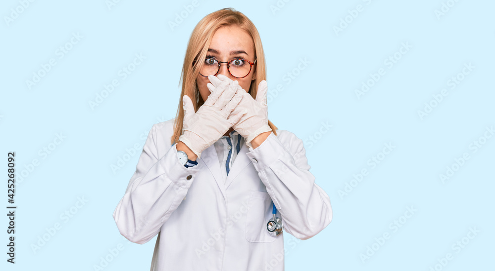 Beautiful caucasian woman wearing doctor uniform and stethoscope shocked covering mouth with hands for mistake. secret concept. Beautiful caucasian woman wearing doctor uniform and stethoscope shocked covering mouth with hands for mistake. secret concept.
