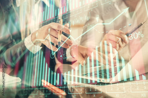 Multi exposure of man and woman working together and financial chart hologram. Business concept. Computer background.