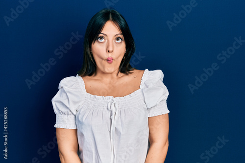 Young hispanic woman wearing casual clothes making fish face with lips, crazy and comical gesture. funny expression.