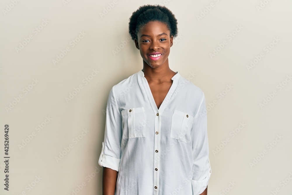 Young african american girl wearing casual clothes with a happy and cool smile on face. lucky person. Young african american girl wearing casual clothes with a happy and cool smile on face. lucky person.
