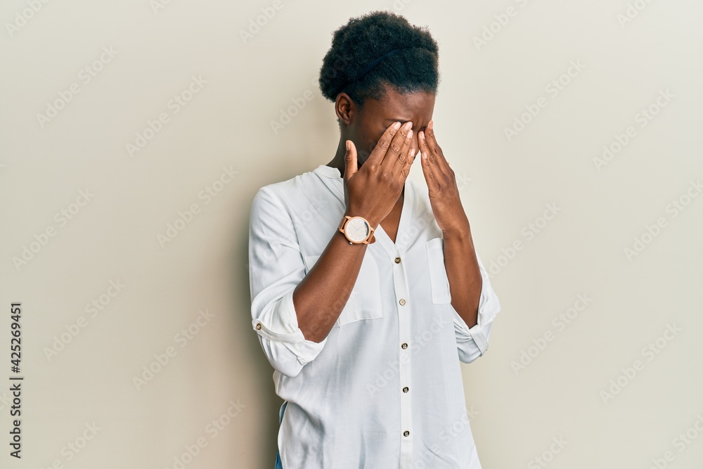 Young african american girl wearing casual clothes rubbing eyes for fatigue and headache, sleepy and tired expression. vision problem Young african american girl wearing casual clothes rubbing eyes for fatigue and headache, sleepy and tired expression. vision problem