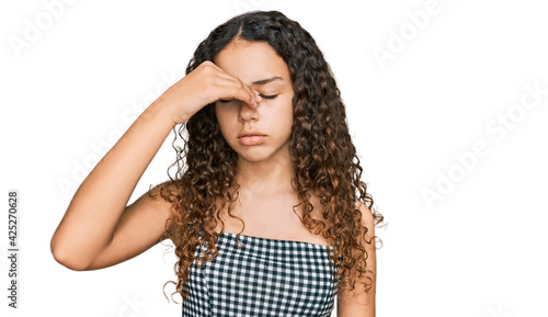 Teenager hispanic girl wearing casual clothes tired rubbing nose and eyes feeling fatigue and headache. stress and frustration concept.