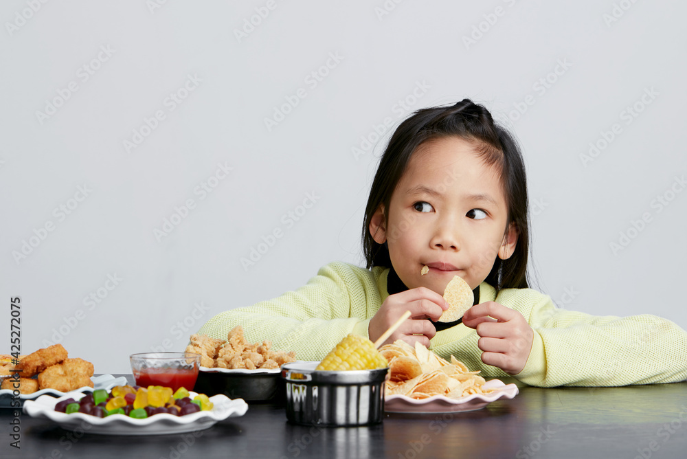 Cute Asian little girl eating happily