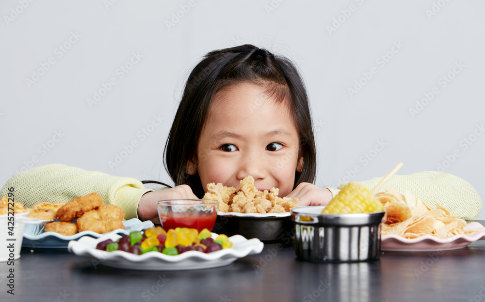 Cute Asian little girl eating happily Cute Asian little girl eating happily