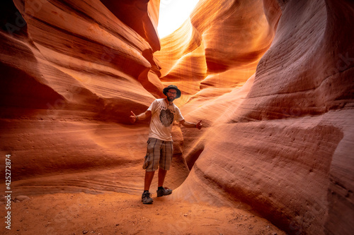 A young tourist with a white shirt in a crack in Lower Antelope.