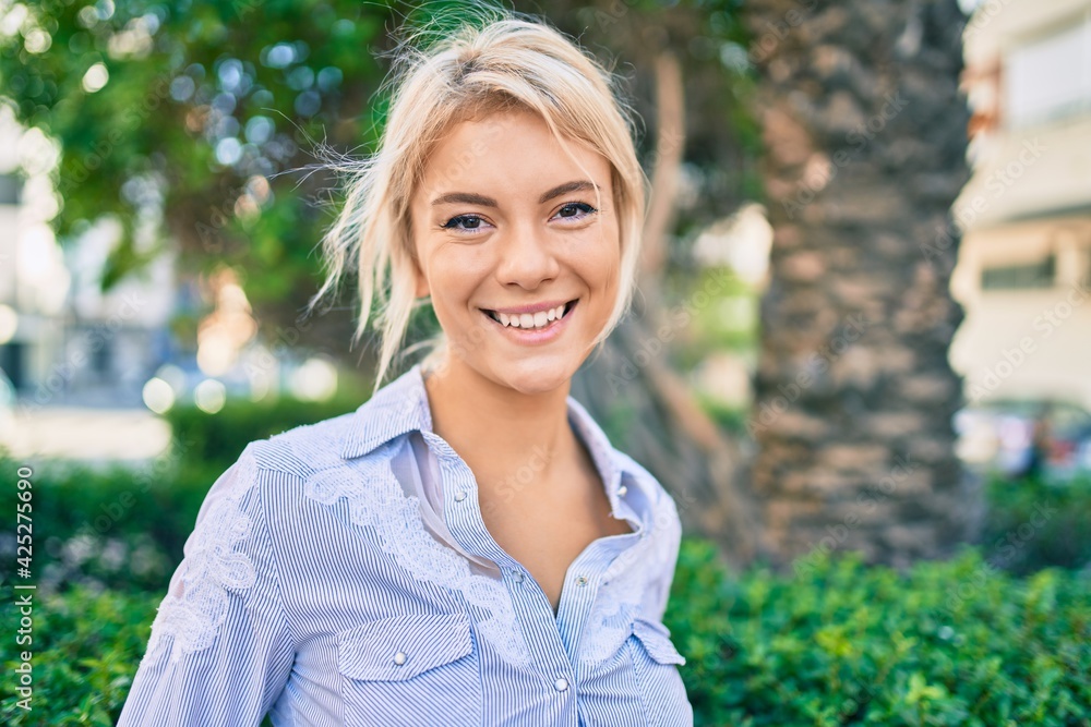 Young blonde woman smiling happy walking at the park. Young blonde woman smiling happy walking at the park.