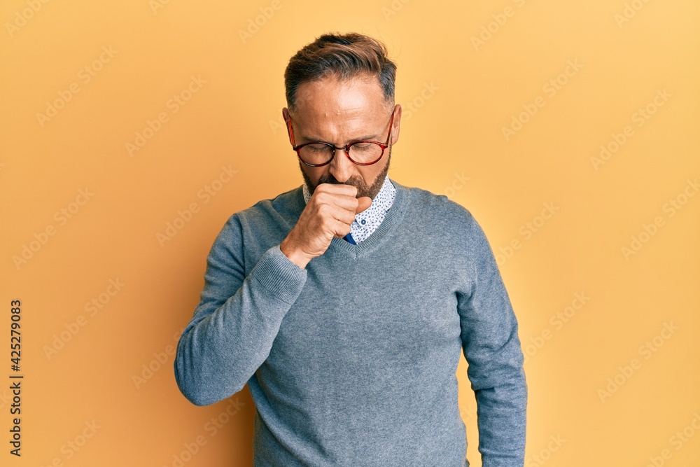 Handsome middle age man wearing glasses feeling unwell and coughing as symptom for cold or bronchitis. health care concept. Handsome middle age man wearing glasses feeling unwell and coughing as symptom for cold or bronchitis. health care concept.