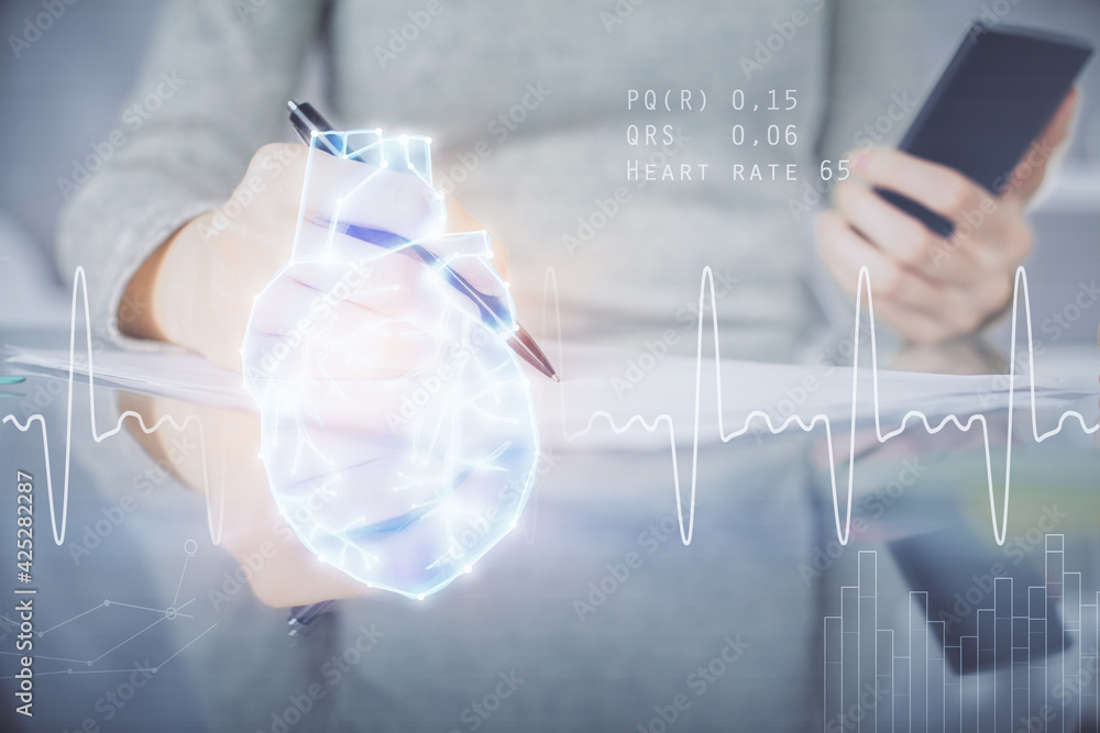 Double exposure of heart sketch hologram and woman holding and using a mobile device. Medical education concept. Double exposure of heart sketch hologram and woman holding and using a mobile device. Medical education concept.