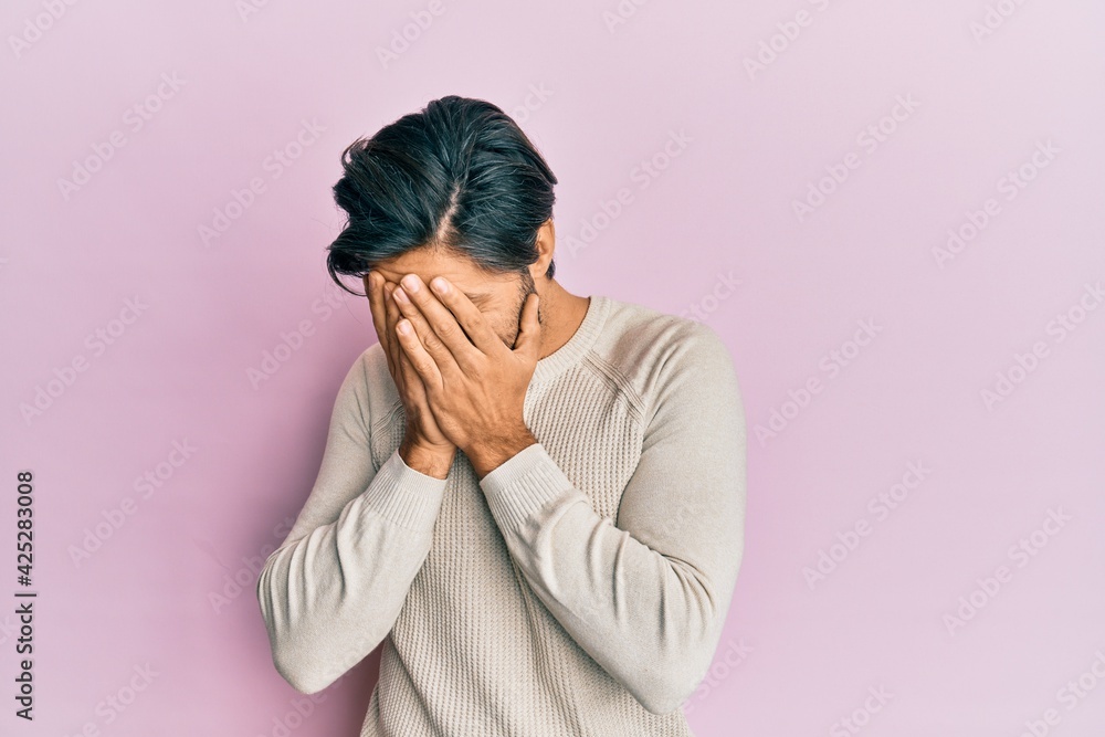 Young hispanic man wearing casual winter sweater with sad expression covering face with hands while crying. depression concept. Young hispanic man wearing casual winter sweater with sad expression covering face with hands while crying. depression concept.
