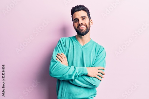 Young handsome man with beard wearing casual sweater happy face smiling with crossed arms looking at the camera. positive person. © Krakenimages.com