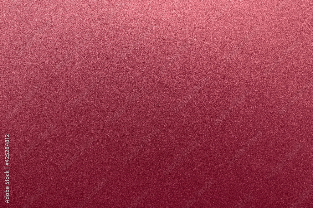 Fototapeta premium Rich red background color. Single-color texture with a small noisy glitter, highlighted on top